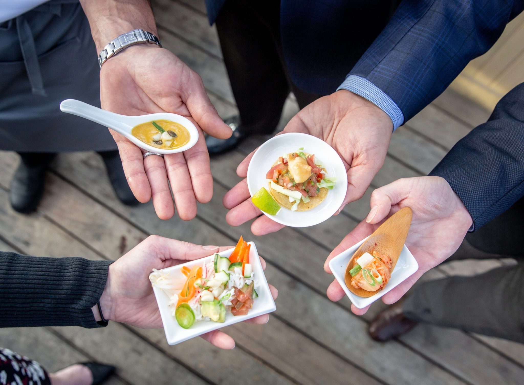 BlueNalu-team-members-holding-four-menu-items-that-demonstrate-BlueNalus-whole-muscle-cell-based-yellowtail-prepared-three-ways-scaled